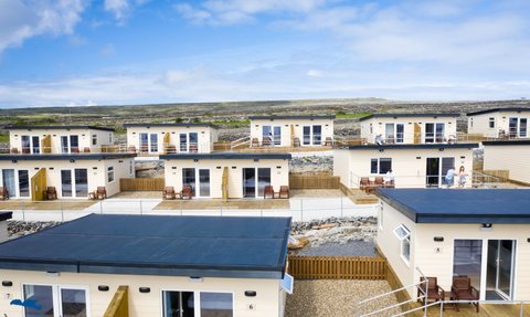 Moderne, helle Hotelzimmer auf Aran Island, umgeben von einer malerischen Landschaft und einem klaren blauen Himmel.