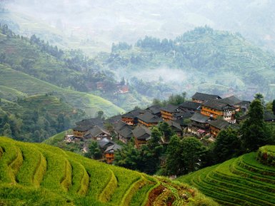Panorama der Reisterrassen von Longsheng mit Blick auf traditionelle Holzhäuser – China Familienreise