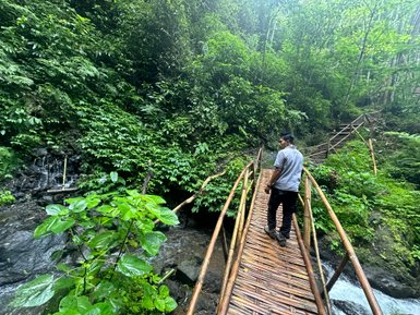 Guide steht auf einer Brücke und führt durch die Landschaft beim Munduk Walk – Bali Reise mit Kindern