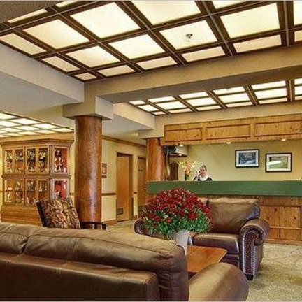 Die Empfangshalle des Cahilty Lodge zeigt eine gemütliche Atmosphäre mit Holzsäulen und bequemen Ledersofas.