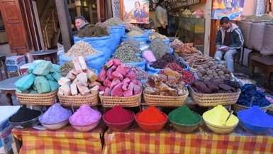 Bunte Gewürze und Heilsteine nebeneinander auf einem Marktstand in Marrakesch – Marokko mit Kindern