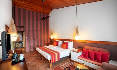 Ein stilvolles Hotelzimmer mit Holzdecke, bunten Wänden und einem gemütlichen Sitzbereich, ideal für Entspannung.