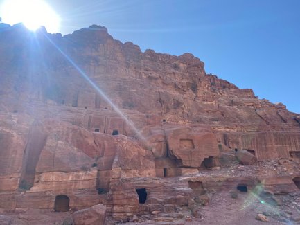 Die majestätischen Felsen von Petra erheben sich unter einem strahlend blauen Himmel, während die Sonne hell scheint.