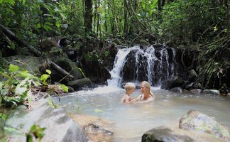 Mutter und Kind genießen das Baden im natürlichen Wasserbecken in La Tigra – Costa Rica Familienreise
