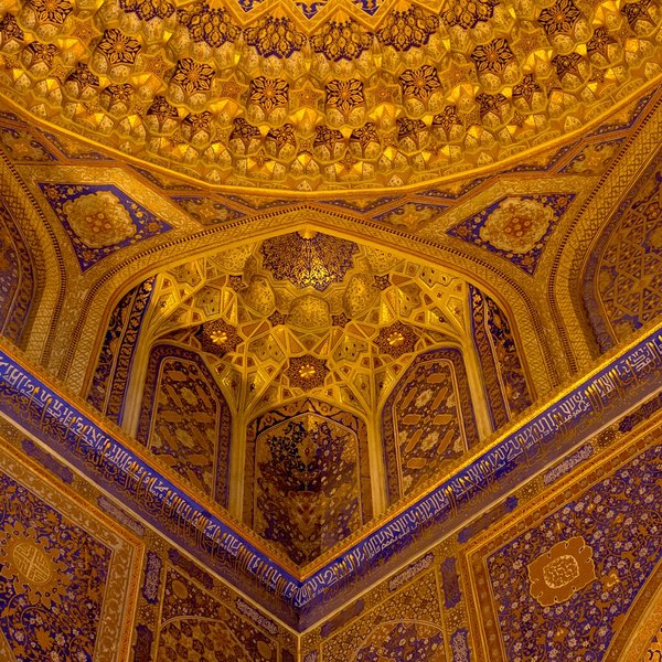 Die kunstvoll gestaltete Decke der Tilya-Kori Medrese zeigt prächtige goldene und blaue Muster, die den Raum erhellen.