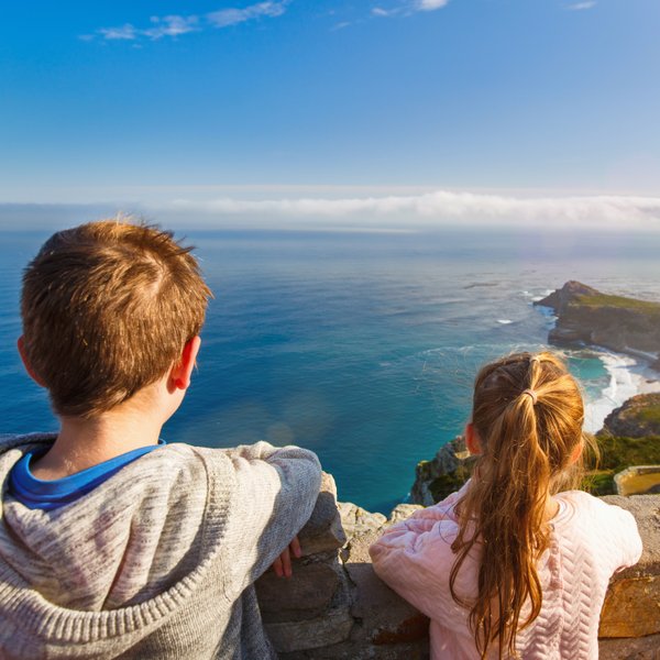 Kinder stehen am Aussichtspunkt des Kaps der Guten Hoffnung und blicken auf das weite Meer – Garden Route Familienreise