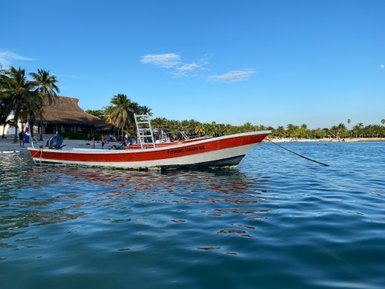 Ruhend im Wasser geparktes Boot an der Küste von Akumal – Mexiko Familienreise