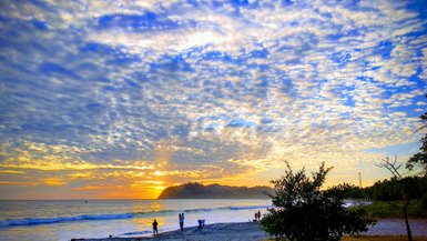 Sonnenuntergang mit orangem Himmel am Strand von Sámara – Costa Rica Reise mit Kindern