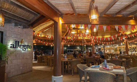 Ein einladendes Restaurant mit warmem Licht, rustikalen Holzelementen und bunten Wimpeln, die eine festliche Atmosphäre schaffen.