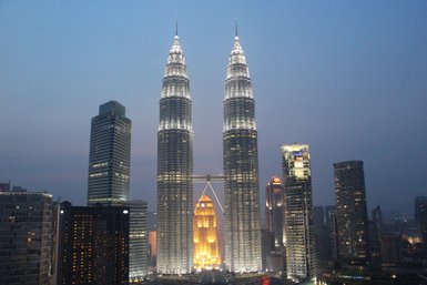 Die beleuchteten Petronas Twin Towers bei Nacht in Kuala Lumpur – Malaysia & Borneo mit Kindern