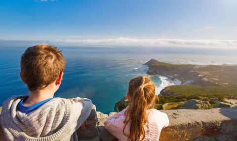 Kinder stehen am Aussichtspunkt des Kaps der Guten Hoffnung und blicken auf das weite Meer – Garden Route Familienreise