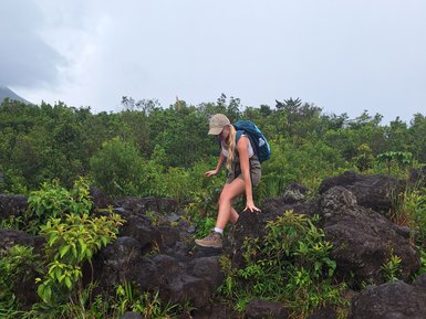 Wanderin auf schwarzem Lavagestein im Vulkan Arenal Nationalpark – Costa Rica Familienreise