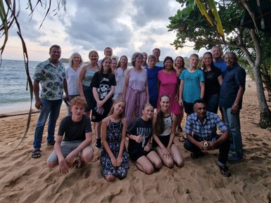 Reisegruppe posiert gemeinsam für ein Foto am Sandstrand unter Palmen – Sri Lanka Familienreise