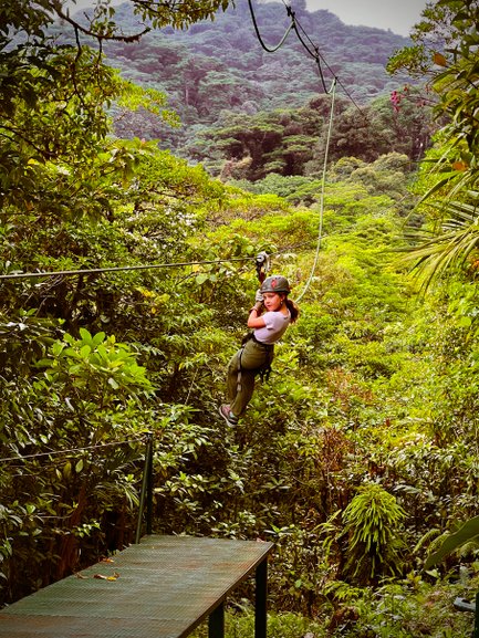 Ein mutiges Mädchen gleitet an einer Zipline durch die Baumwipfel des Regenwaldes – Costa Rica Familienreise