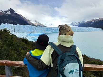 Eine Frau und ein Kind stehen am Geländer und betrachten den beeindruckenden Perito-Moreno-Gletscher in Patagonien.