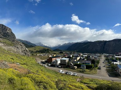 Eine malerische Ansicht von El Chaltén, umgeben von majestätischen Bergen und blühenden Wiesen im Vordergrund.