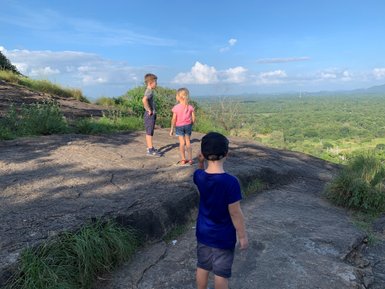 Kinder klettern auf große Felsen inmitten grüner Natur – Sri Lanka Reise mit Kindern