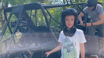 Kind steht neben einem Quad-Buggy während einer Tour auf Bali – Bali Familienreise