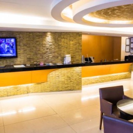 Der Empfangsbereich des Atlantis Copacabana Hotels zeigt eine elegante Theke aus Stein mit stilvoller Beleuchtung.