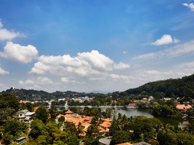 Panoramablick auf die Stadt Kandy mit grüner Landschaft und Häusern im Tal – Sri Lanka Familienreise