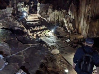 Entdecker erkundet geheimnisvolle Tropfsteinhöhle mit Laterne – Thailand Familienreise