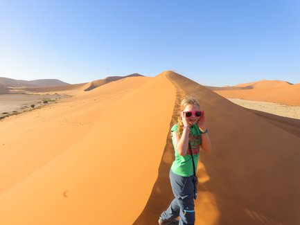 Ein Kind läuft eine Düne hinauf - Namibia Urlaub mit Kindern