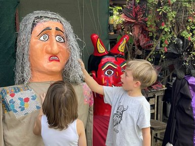 Glückliche Kinder halten bunte Figuren von Maskenbildner Toni – Costa Rica Reise mit Kindern