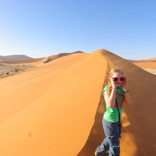 Ein Kind läuft eine Düne hinauf - Namibia Urlaub mit Kindern