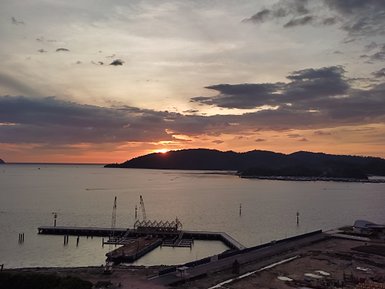 Sonnenuntergang taucht den Himmel über Kota Kinabalu in leuchtendes Orange – Malaysia & Borneo mit Kindern