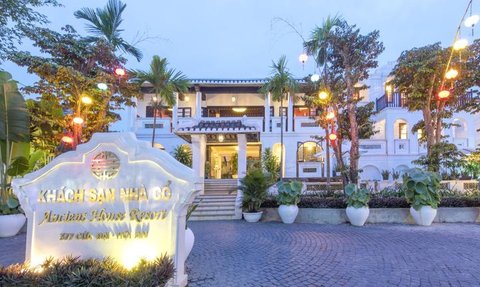 Das Ancient House Resort in Hoi An zeigt eine elegante Fassade mit bunten Laternen und üppiger Vegetation im Vordergrund.