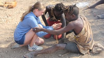 Besucherin übt das Feuer machen mit dem Hadzabe-Stamm – Tansania Familienreise