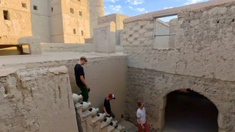 Familie geht die Treppen im Bahla Fort im Oman hinunter – Oman Reise mit Kindern