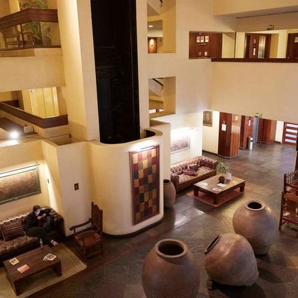 Ein eleganter Hotel-Lobby mit gemütlichen Sofas, großen Töpfen und einer einladenden Atmosphäre für Gäste.