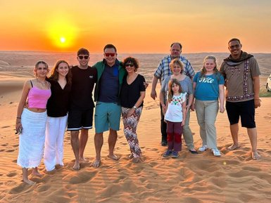 Familie macht gemeinsames Foto beim Sonnenuntergang in der Wahiba-Wüste – Oman Familienreise