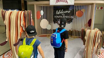 Zwei Kinder kommen mit Gepäck am Flughafen in Südafrika an – Südafrika Familienreise