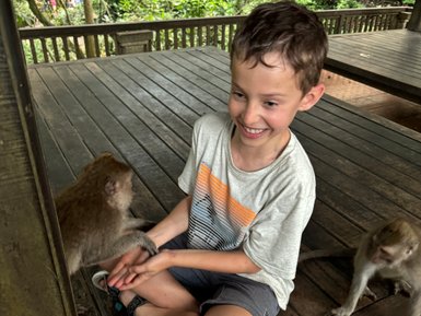 Kind interagiert mit Affe im Sacred Monkey Forest Sanctuary – Bali mit Kindern