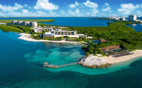 Ein luxuriöses Resort am Wasser, umgeben von üppigem Grün und klarem, türkisfarbenem Wasser, ideal für Entspannung.