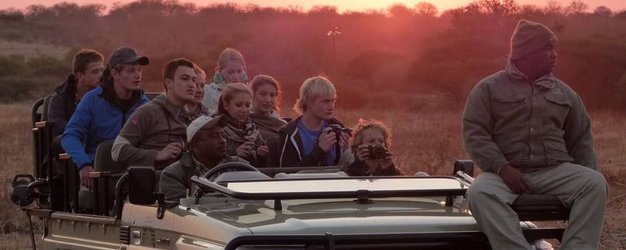 Reisegruppe im offenen Safari-Jeep entdeckt die Tierwelt bei Nacht – Südafrika mit Kindern