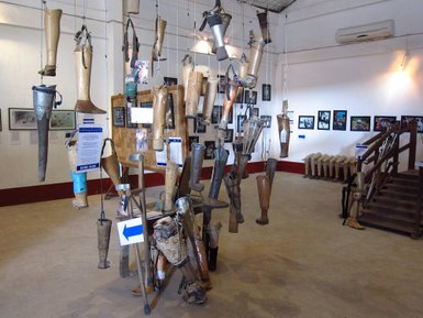Eine Ausstellung mit zahlreichen hängenden Prothesen, die die Auswirkungen des Krieges auf die Menschen in Laos verdeutlichen.