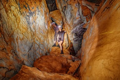 Zwei Menschen erkunden gemeinsam das Innere einer Höhle - Namibia Rundreise mit Kindern