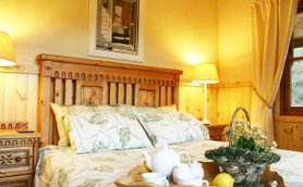 Ein gemütliches Schlafzimmer mit einem Holzbett, dekoriert mit blattförmigen Kissen und sanftem Licht von den Nachttischlampen.