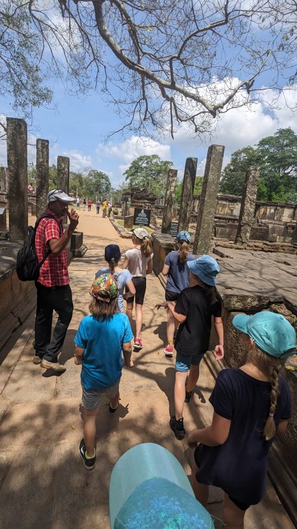 Kinder lauschen einem Guide bei den historischen Ruinen von Polonnaruwa – Sri Lanka Familienreise
