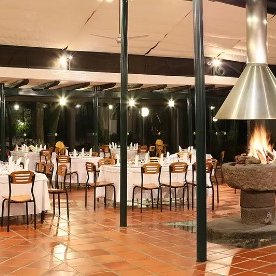 Ein elegantes Restaurant mit weißen Tischdecken und Holzstühlen, das eine einladende Atmosphäre ausstrahlt.