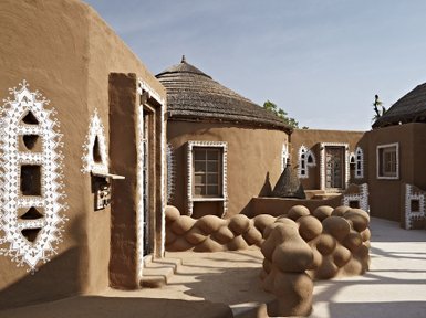 Eine malerische Ansicht eines traditionellen Hotels mit erdigen Wänden und kunstvollen weißen Verzierungen.