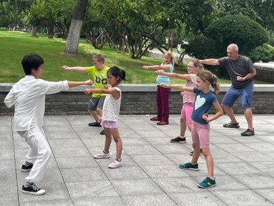 Eltern und Kinder üben gemeinsam Schattenboxen im Park von Xi’an – China Reise mit Kindern