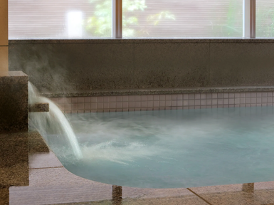 Ein entspannendes Thermalbad mit dampfendem Wasser, das sanft über die Kante fließt und eine ruhige Atmosphäre schafft.