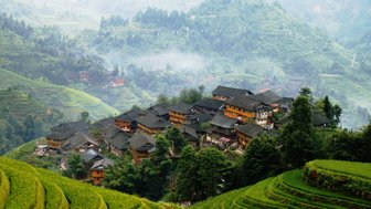 Panorama der Reisterrassen von Longsheng mit Blick auf traditionelle Holzhäuser – China Familienreise