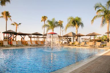 Ein einladender Pool mit sprudelndem Wasser, umgeben von Liegen und Palmen, ideal für entspannende Tage am Atlantik.