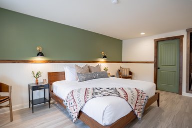 Ein stilvolles Zimmer mit einem großen, einladenden Bett, dekoriert mit einer roten und weißen Decke.