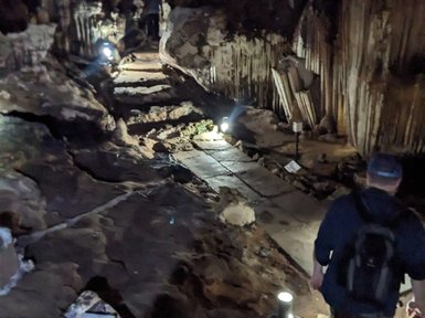 Entdecker erkundet geheimnisvolle Tropfsteinhöhle mit Laterne – Thailand Familienreise
